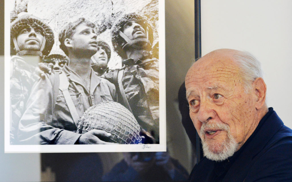 Israeli photographer David Rubinger poses with his famous photo of three Israeli paratroopers after the recapture the Western Wall in the Six-Day War at an exhibition called "Israel Through My Lens" in Old Town Hall, Prague, Czech Republic, on July 3, 2014. (CTK Photo/Michal Dolezal)