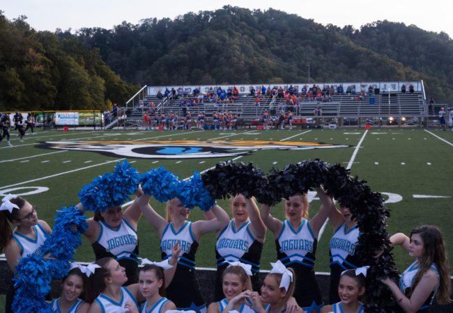 Floyd Central High School cheerleaders form their pom-poms into a heart shape for a group photo before a football game in Langley, Ky., on Friday, September 22, 2017. (Photo by Brittany Greeson/GroundTruth)