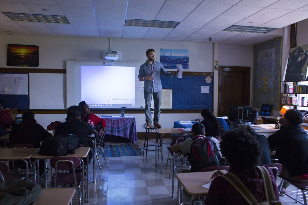 Brian Damboise, an English and journalism teacher at the High School of Commerce, stands on a stool in order to get the attention of his students at the beginning of their class in Springfield, Mass., on Monday, September, 11, 2017. (Photo by Brittany Greeson)