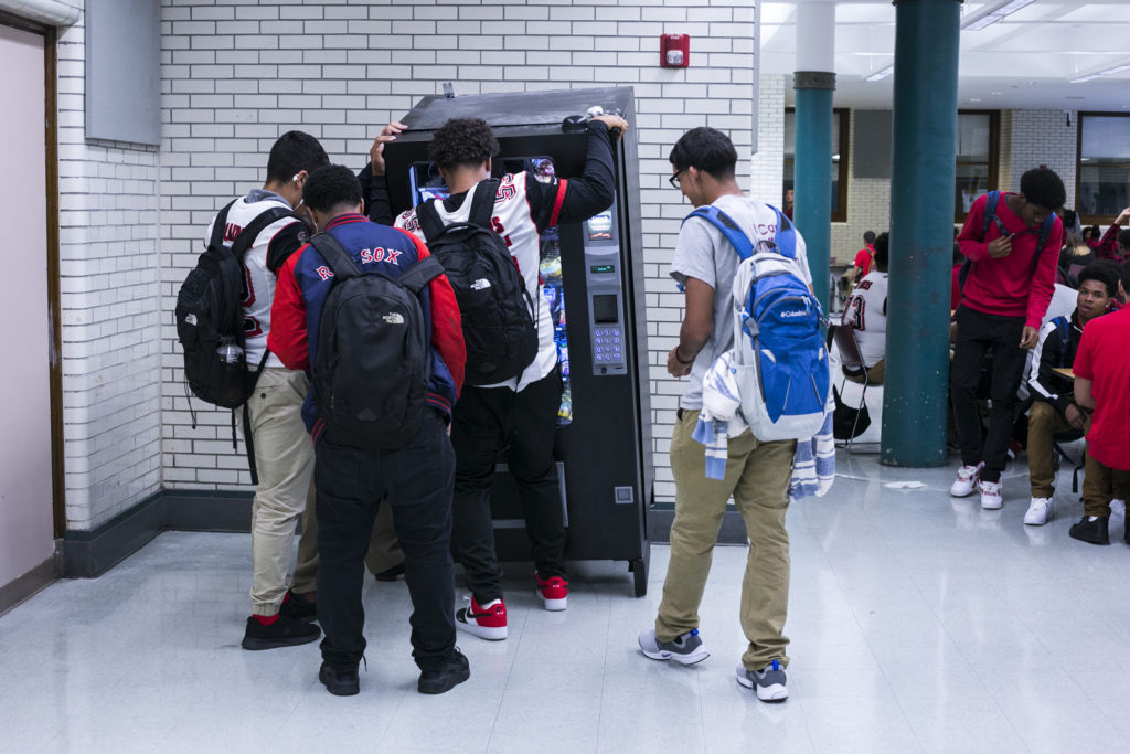 Students work together to tip a vending machine after a brownie got stuck in its rings during lunch period at the High School of Commerce in Springfield, Mass., on Friday, September, 8, 2017. (Photo by Brittany Greeson)