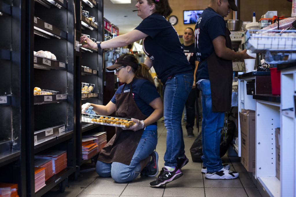 Jennilease Gomez, 17, shifts trays of donuts at the Dunkin Donuts where she works on the weekends in South Hadley, Mass., on Saturday, September, 10, 2017. Gomez said she originally got the job in order to help support her brothers, 11 and 7, as her mother has a hearing disability which holds her back from working. This year she bought her siblings' school clothes. (Photo by Brittany Greeson)