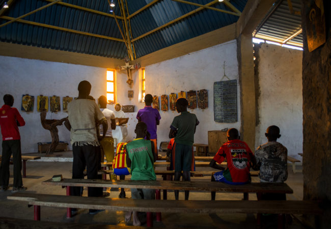 Father Florian gives an afternoon service in Illeret, Kenya. He took his vows at St. Ottilien Archabbey, where he adopted the Benedictines' unofficial motto, “Ora et Labora” — “Pray and Work.” This has become his mantra for his time with Kenya's ethnic Daasanach community, one of the smallest tribes in Kenya. (Christena Dowsett/The GroundTruth Project)
