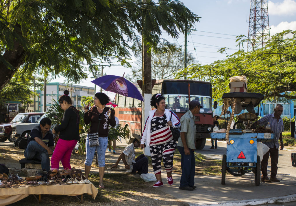 A woman walks around Sandino wearing American flag-patterned clothing. (Photo by Desmond Boylan/GroundTruth)