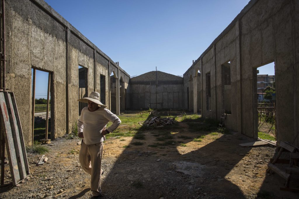 A man walks through the framing of what will soon be the first Catholic church to exist in Cuba since Fidel Castro took over in 1959. (Photo by Desmond Boylan/GroundTruth)