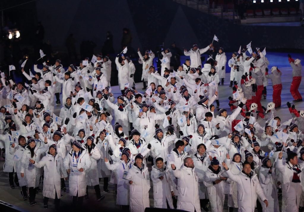 Athletes from South Korea and North Korea enter the Olympic stadium on February 9, 2018, under a unity flag depicting the Korean peninsula. (Andy Miah/Flickr Creative Commons)