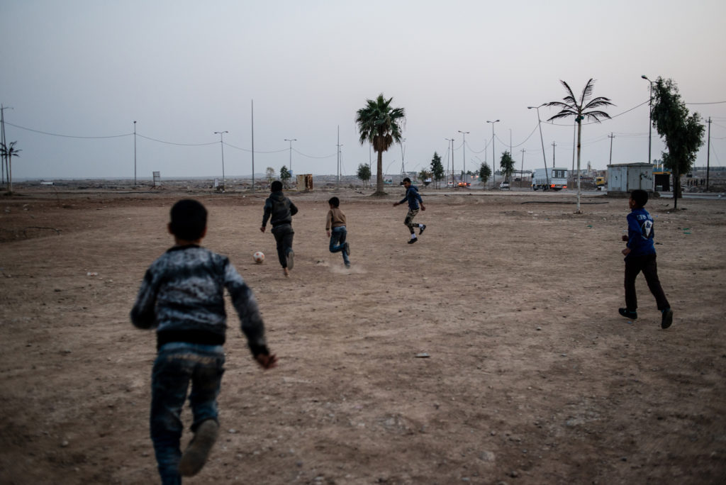 Iraqi children play football at Baghdad Circle, the entrance to West Mosul, on January 14, 2018. (Alex Potter/GroundTruth)
