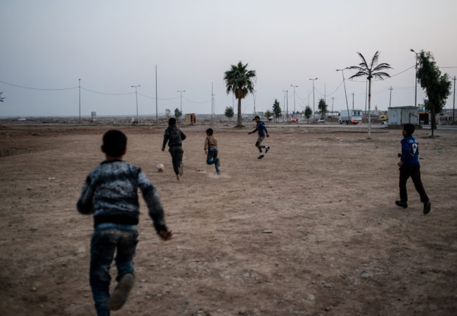 Iraqi children play football at Baghdad Circle, the entrance to West Mosul, on January 14, 2018. (Alex Potter/GroundTruth)