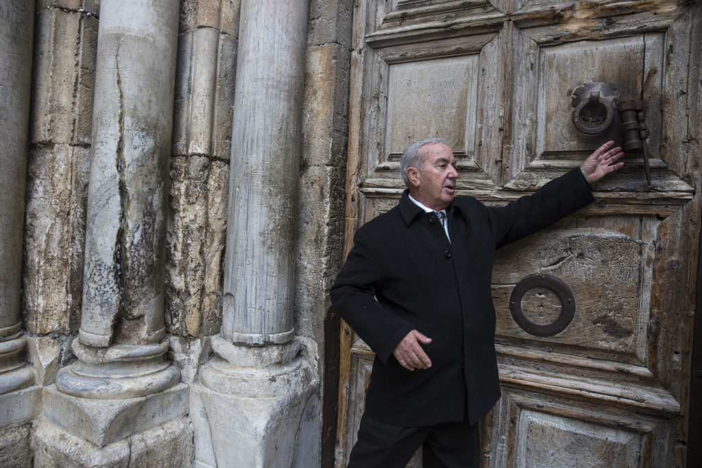 Mr. Wajeeh Nuseibeh outside one of the giant wooden doors of the Church of the Holy Sepulchre on Good Friday, March 30, 2018. The Nuseibeh family, a Muslim family, has been Door Keeper for generations. (Heidi Levine/The GroundTruth Project)