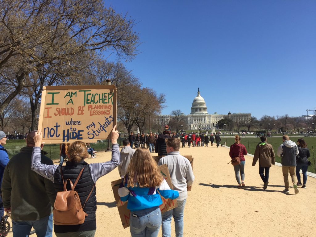 A woman holds a sign reading, "I am a teacher. I should be planning lessons, not where to hide my students," at the March For Our Lives rally in Washington, D.C. on March 24, 2018. (Photo by Kevin Grant)