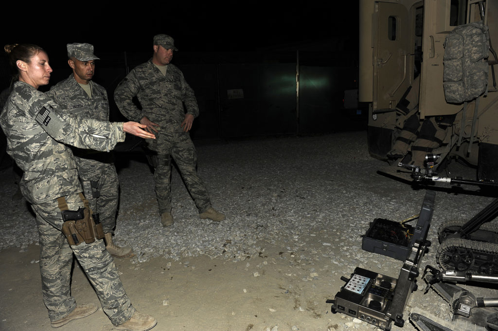 U.S. Air Force Staff Sgt. Elizabeth Butler was one of the few women bomb techs on the Explosive Ordnance Division of the Air Force. She demonstrates a Packbot, a robot that helped her and her team disable IEDs, at Bagram Airfield in Afghanistan on Dec. 29, 2009. (Photo courtesy of Elizabeth Butler)