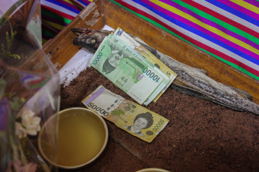 During the ceremony, Choi offered more money in addition to the price she had already paid. Shamanic ceremonies have a history of being expensive, so people that can’t afford them will sometimes seek counseling from shamans for a lower price; one that does not include offerings to the gods or a fully fleshed out performance. (Miranda Mazariegos/GroundTruth)