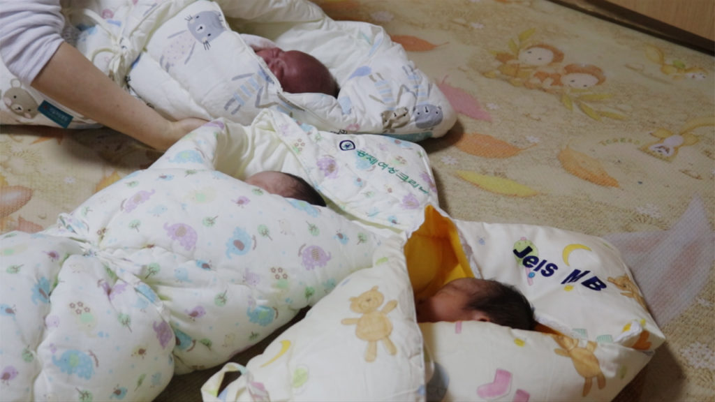 Three infants from the baby box are swaddled and ready to be transported to the public children's hospital. (Paulina Cachero/GroundTruth)