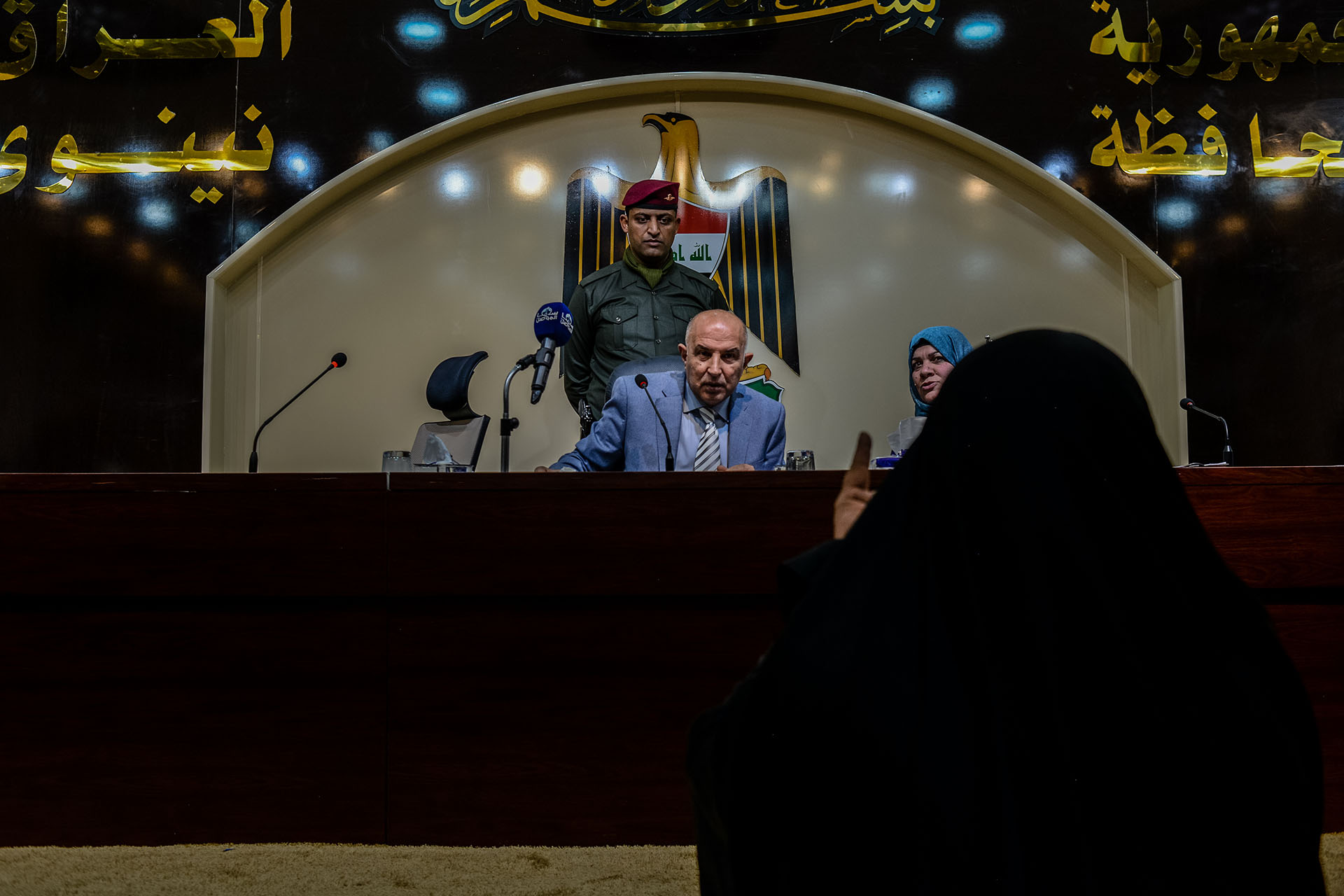 Mosul Governor Nofal Hammadi holds a public meeting to hear the concerns of citizens, and speaks to a widow who is asking for financial support.  (Alex Potter/GroundTruth)