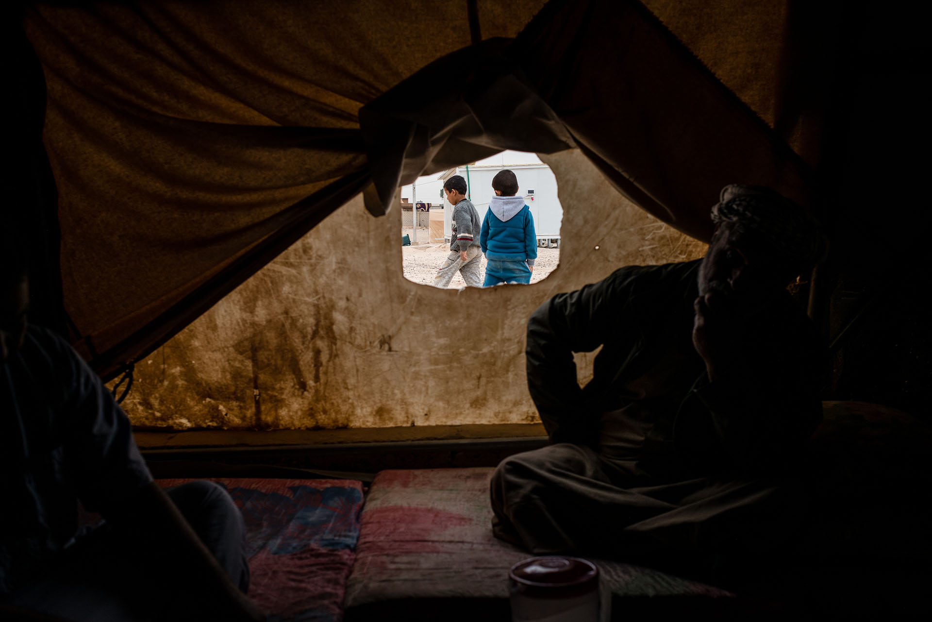 Young boys play outside a tent in Shahama camp, a settlement that holds families with direct or suspected ties to ISIS. (Alex Potter/GroundTruth)