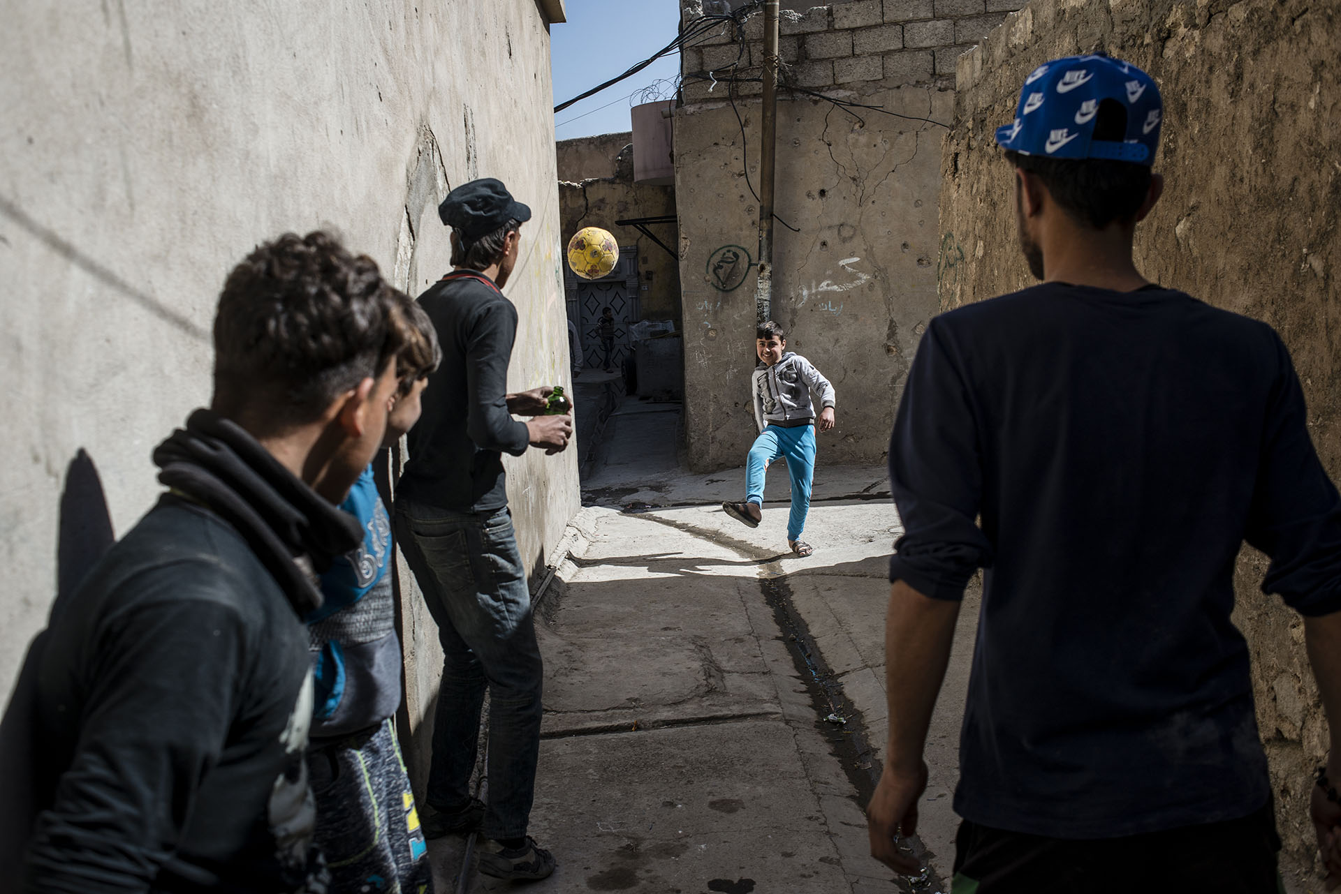 Ali, a boy who lost his arm in a mortar strike while his family was displaced, plays with his friends in the Old City once again.  (Alex Potter/GroundTruth Project)