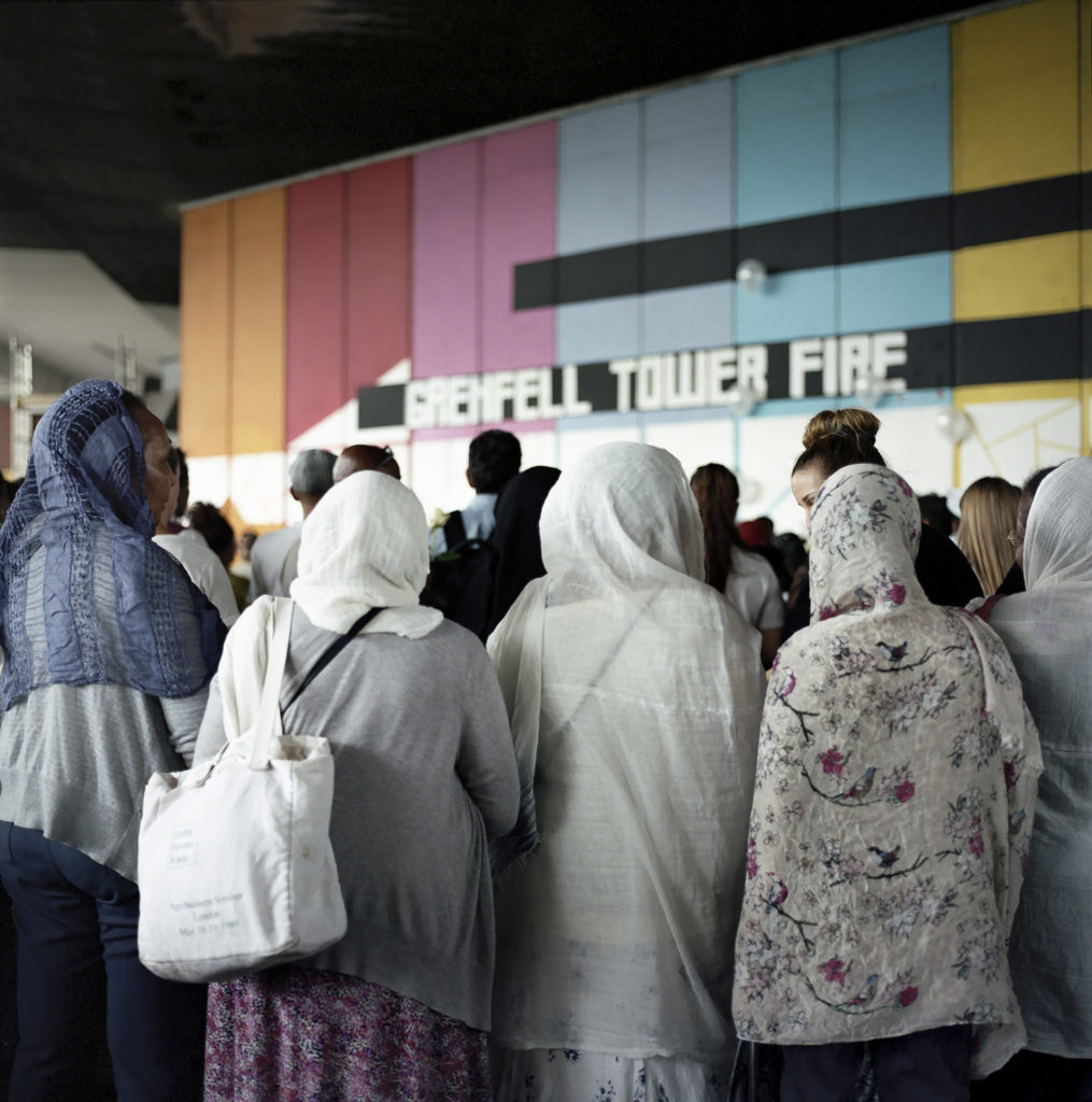 Local residents of the North Kensington community gather round the Wall of Truth, located under the West Way, dedicated to families and survivors of the Grenfell Fire. (June 14th, 2018).