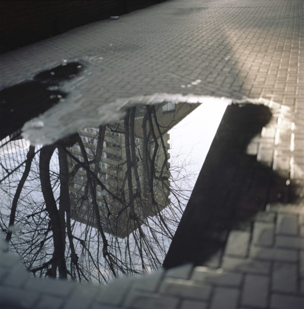 The Whistable Estate, one of the first tower blocks built on Latimer Road in North Kensginton, reflected in a pool of water beneath the West Way. Many residents of this estate had to witness the fire throughout the morning of june 14th, 2017 - watching their friends and neighbors perish in the fire.