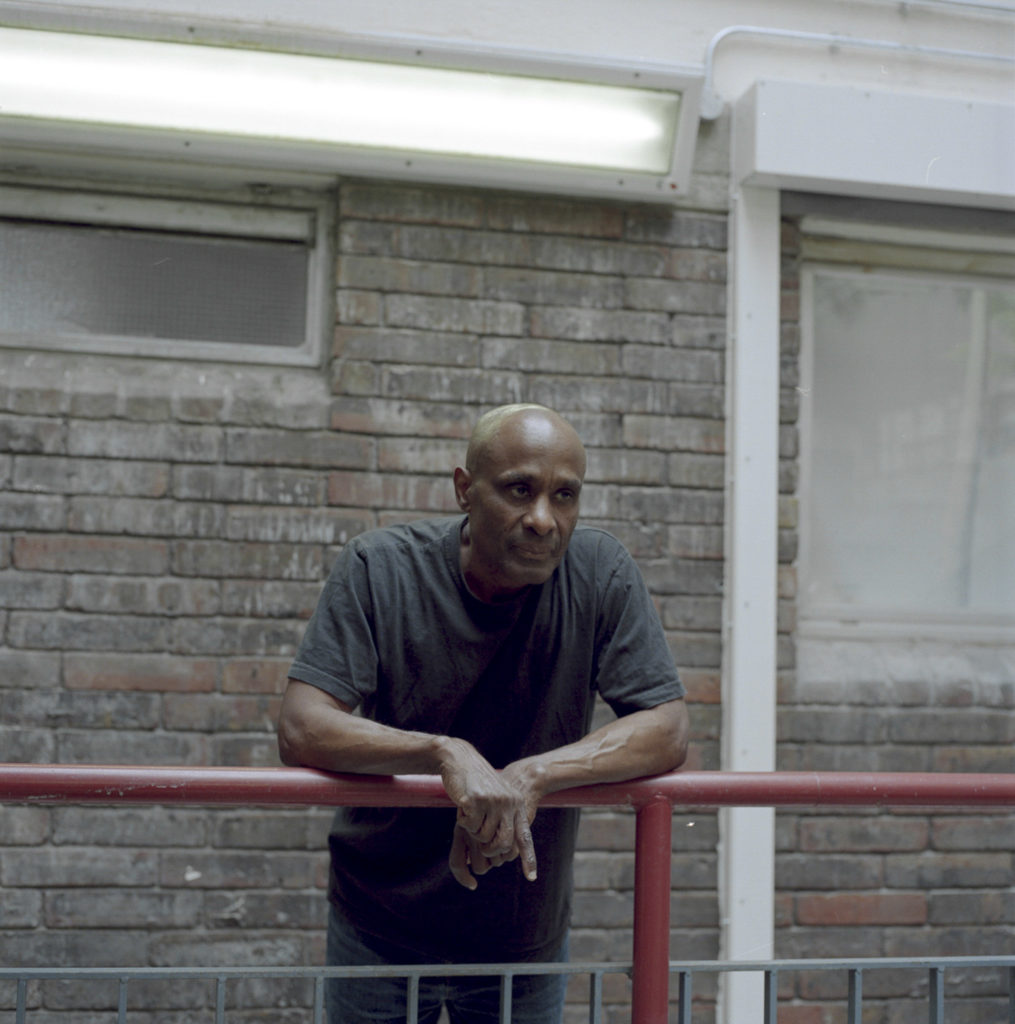 Joseph Alfred of Hurstway Walk Lancaster Estate W10, Resident for over 40 years. stood in the halls of his housing block. The Lancaster Estate stands immediately next to Grenfell Tower, and parts of the estate were badly damaged from the fire. The residents there were one of the first to see the beginnings of the fire - trying to signal to their Grenfell neighbours to come down from the top floors. Joseph lost a close friend who lived in the highest levels of the tower block.