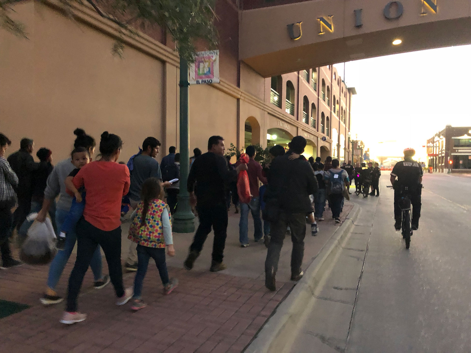 A group of immigrants walks under the "Union" arch on their way to a church where they'll find shelter for the night. (Photo by: Mallory Falk/GroundTruth)
