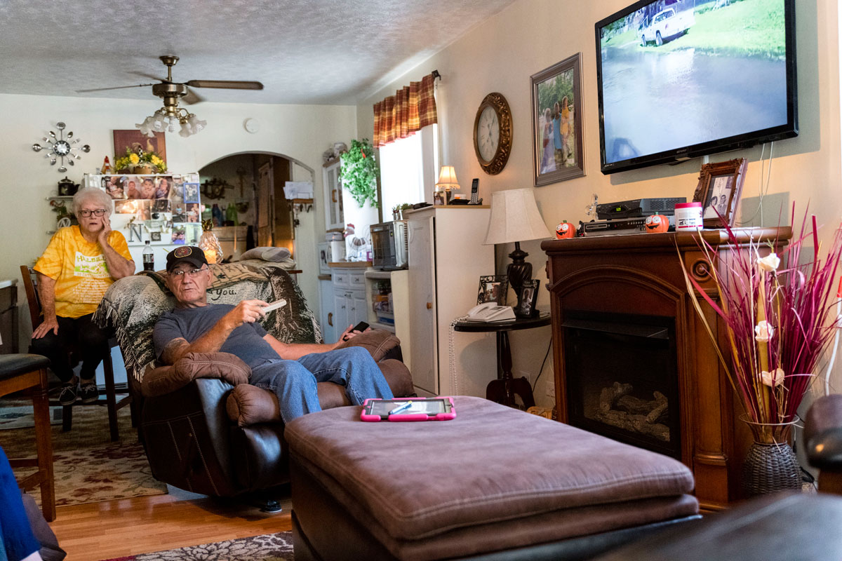 Naomi and James Stollings show reporters a video on Oct. 2, 2018, of raw sewage running in the road outside their house earlier. CREDIT JESSE WRIGHT / WEST VIRGINIA PUBLIC BROADCASTING