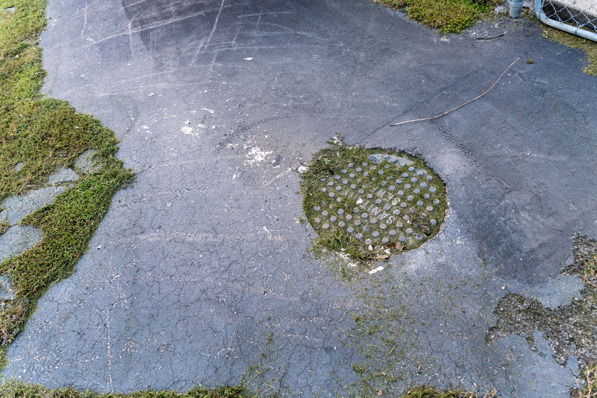 Toilet paper litters the ground Oct. 2, 2018, near a manhole cover in Chattaroy, Mingo County, W.Va., out of which residents say raw sewage flows any time the area receives significant rainfall. CREDIT JESSE WRIGHT / WEST VIRGINIA PUBLIC BROADCASTING