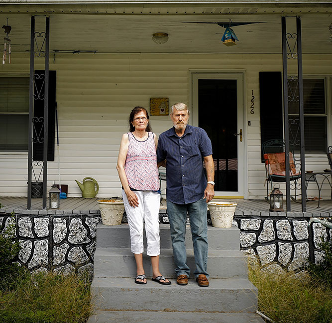 Betty and Calvin Jude, of Inez, stood on the front porch of their home on Tuesday, Oct. 2. Both lifelong residents of Martin County have worried about the county’s water quality for years. The Judes use bottled water for all cooking and drinking and say the water irritates their skin when bathing. Betty was diagnosed with breast cancer in 2011 and believes contaminates in the tap water caused it. Photo by Alex Slitz / aslitz@herald-leader.com