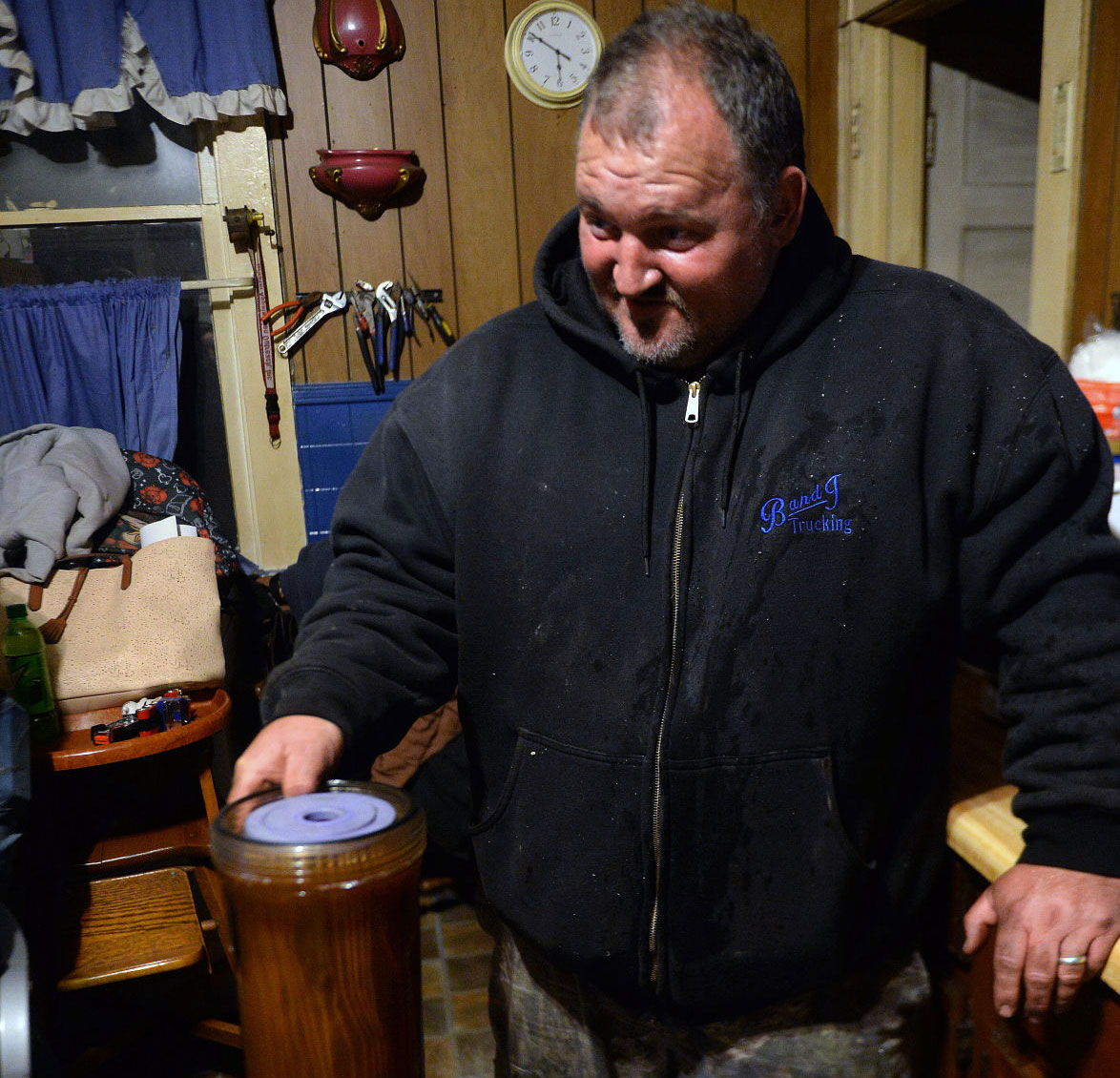 Chris Coleman, of Gary, holds a water filter he just removed from his family's water system. The reddish-brown, muddy water is what flows into their pipes before it hits the filter, he said. (Photo by F. Brian Ferguson | Gazette-Mail)