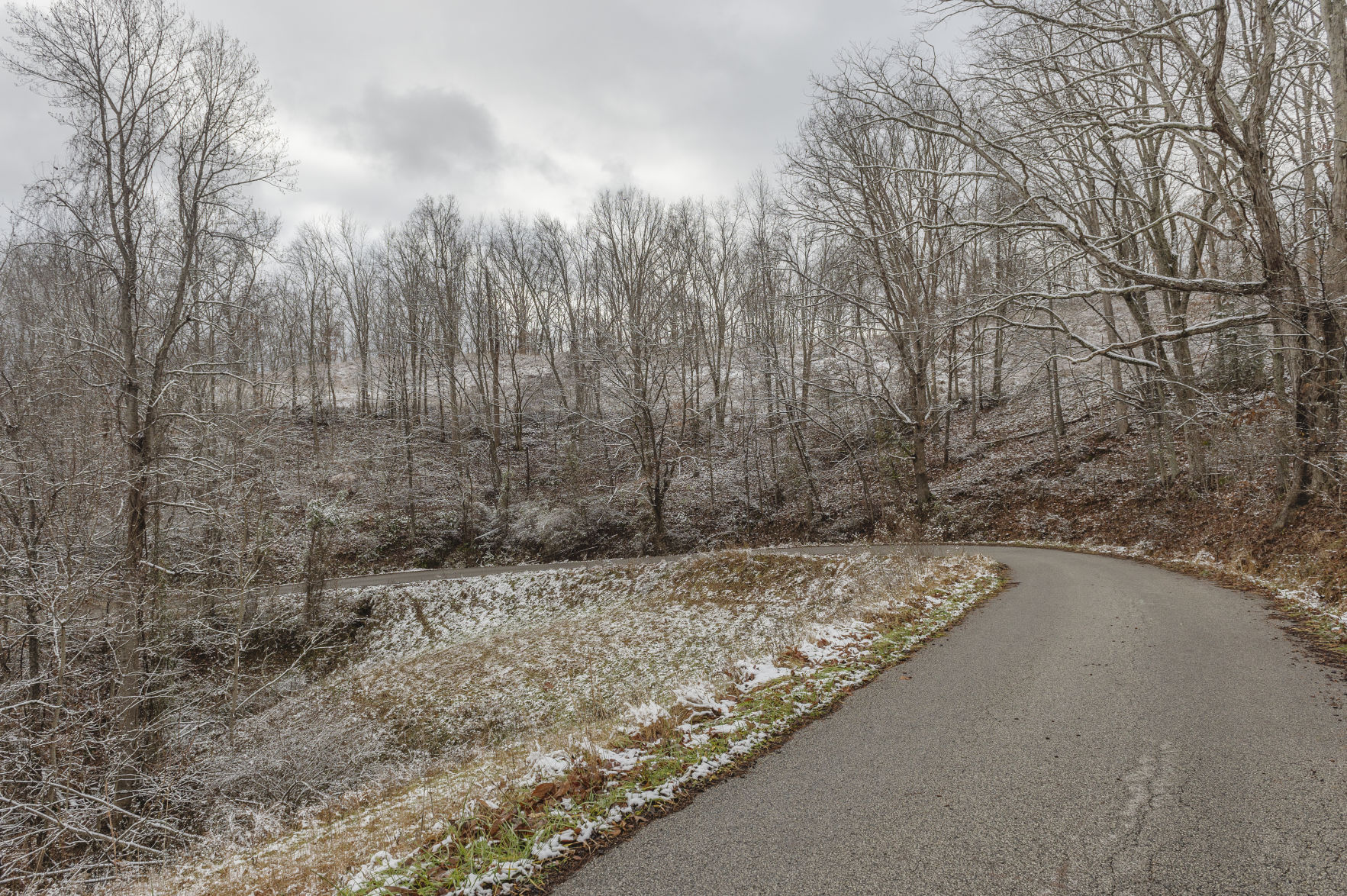 Allen Adkins and his brothers and sisters live off this curve in Harless Fork Road, in Lincoln County. Adkins remembers his father thought he'd die before seeing a paved road cut through the hollow. Today, Adkins wonders if he will feel the same about water service. (Photo by Craig Hudson | Gazette-Mail)
